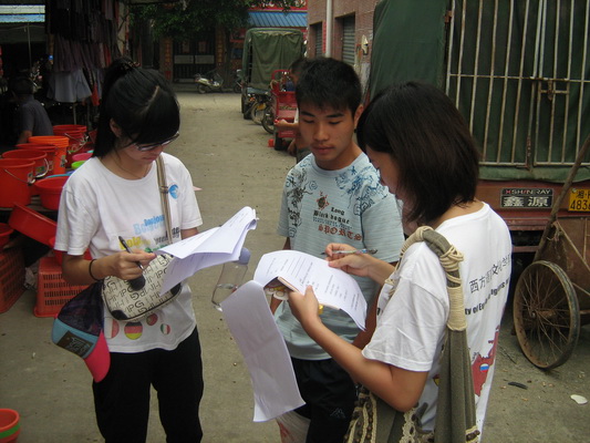 调研组组员正就文化站的相关问题采访某位民众