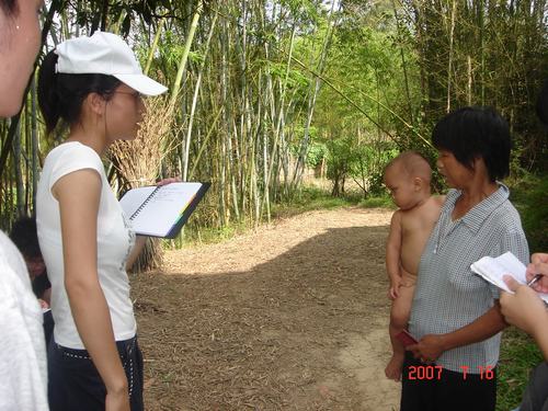 阿姨抱着留守的孩子接受我们的采访,孩子以最原始的状态面对我们