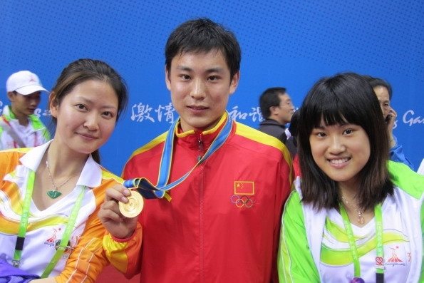 陈洁(右一)与亚运首金得主袁晓超合影