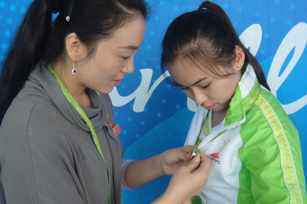 亚组委工作组成员为志愿者佩戴小牌