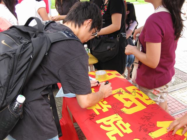 同学们纷纷在横幅上签名以表决心