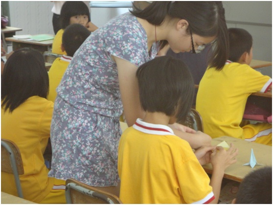 课堂上,老师在耐心地手把手教孩子们折纸 课堂上,老师在耐心地手把手教孩子们折纸